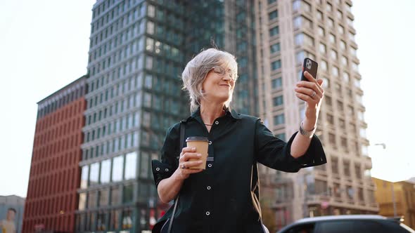 Attractive Businesswoman Talking on Video Communication Using Phone While Standing in the Middle of
