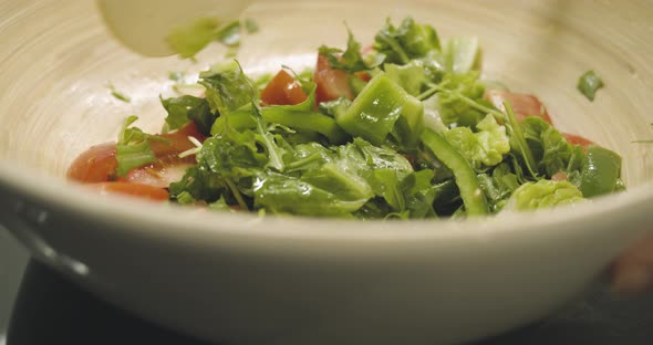 Fresh healthy salad is stirred in a large cup