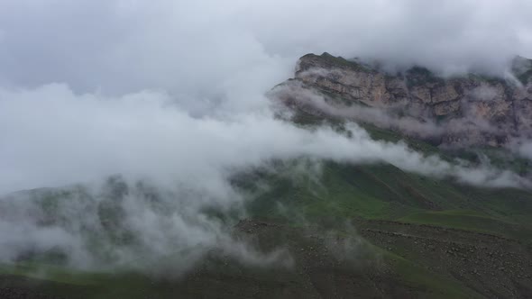 Flight in the clouds above rock