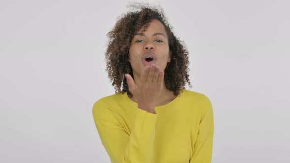 Young African Woman Giving Flying Kiss By Hands on Yellow Background