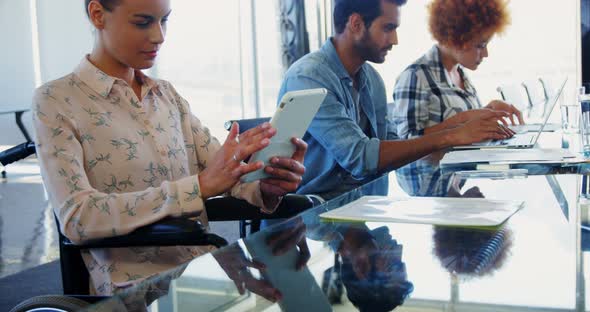 Executives working on electronic gadgets in office