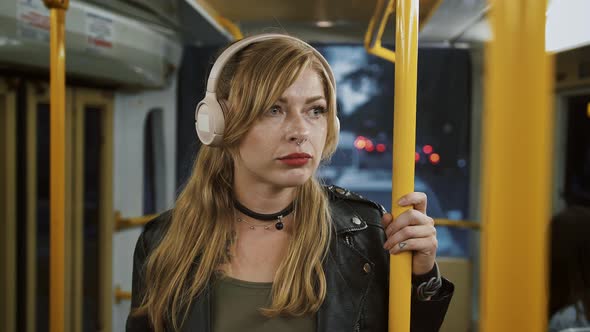 Sad Female Hipster in Headphones is Listening to Music