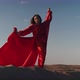 An Asian Woman in a Red Dress Gets Into a Pose on One Leg on Sand Dunes - VideoHive Item for Sale