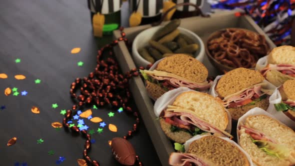 Game day football party table with  sub sandwich and snacks.