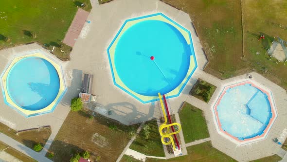 Aerial view of empty pools with slides in abandoned aqua park.