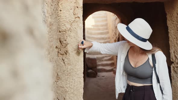 Caucasian Woman in Summer Hat and Clothes Using Brush While Digging Ruined