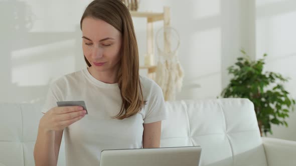 Young Businesswoman at Home Makes a Purchase on the Internet