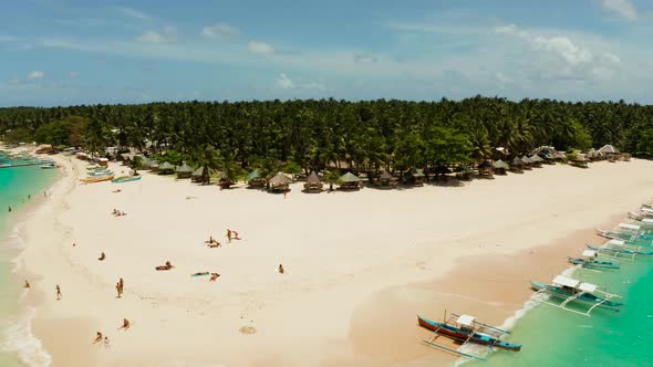 Tropical Daco Island with a Sandy Beach and Tourists