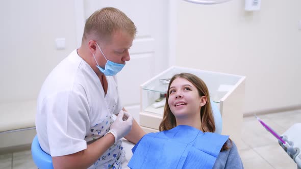 Dentist talks to a female patient.