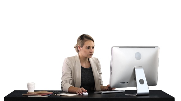 Beautiful blonde woman working on computer, white background