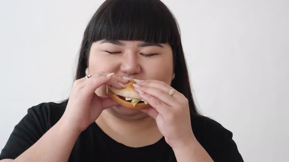 Asian Girl Eats a Burger