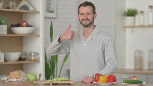 Young Man Showing Thumbs Up While Standing in Kitchen
