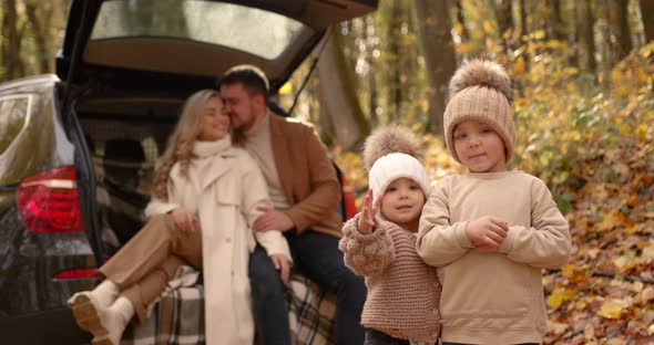 Young Family Sitting in the Trunk of a Car in Autumn