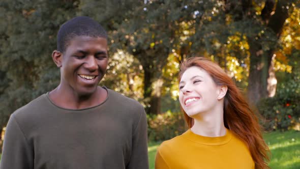 smiling Beautiful young mixed race couple walking in the park- slow motion