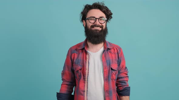 Positive Bearded Guy Saluting with Hand, Saying Yes Sir Wit, Isolated on Turquoise Background