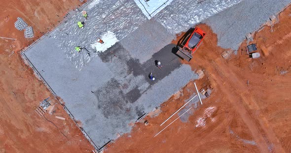 An Excavator Bucket is Being Used for Pouring Concrete on the Foundation of a Building on a