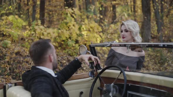 Portrait of Romantic Couple Looks on Each Other at Retro Car