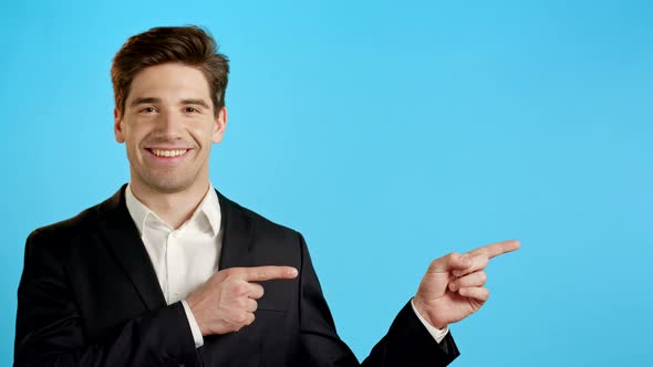 Happy Smiling Businessman Presenting and Showing Something Isolated on Blue Background. Portrait of