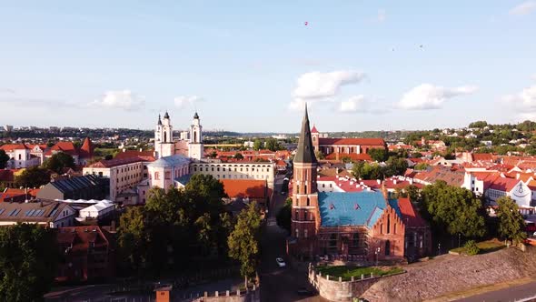 Kaunas city old town aerial drone shot while the drone is flying forwards. Beautiful church towers a