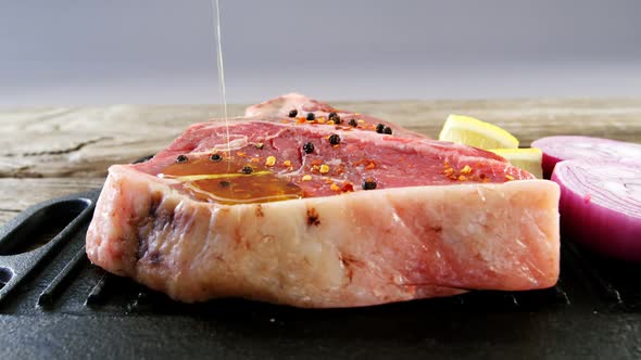 Oil being poured on marinated steak