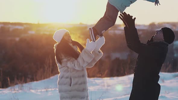 Tremendous Parents Play with Toddler Son in Winter at Sunset