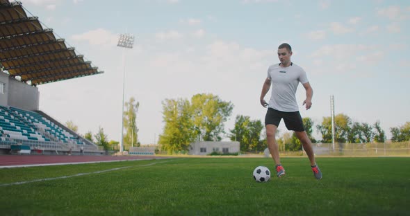 Skill Professional Soccer Player a Man Runs in with a Soccer Ball on a Soccer Field in a Stadium