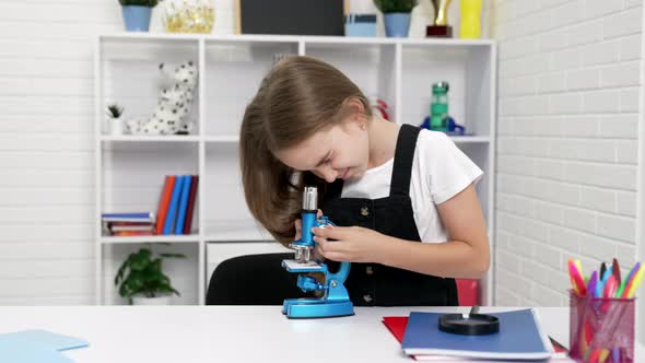 Scientist Teen Girl Look Through Microscope on Chemistry Lesson Curiosity