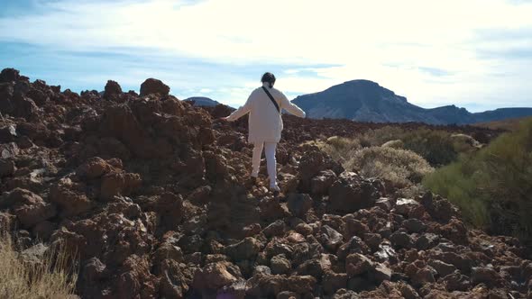 Tourist Woman Walk Through the Mountains of Solidified Lava in the Teide Volcano National Park on