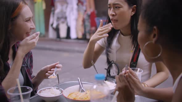 A group of multi-ethnic female friends enjoying street food on Yaowarat Road or Chinatown in Bangkok