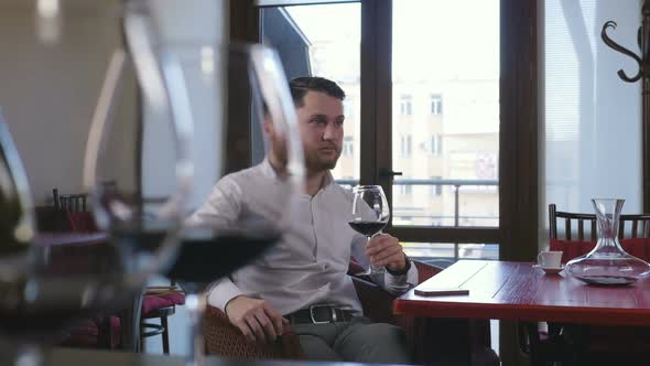Young Man Drinking Wine From a Glass in Restaurant Slow Motion Dolly Shot
