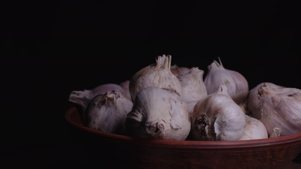 Pile of Whole Bulbs of Garlic in Ceramic Bowl on Table