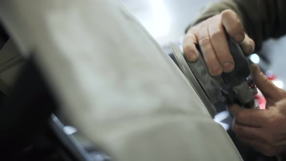 polishing of the damaged car door with a grinder