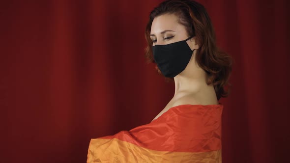 Large Rainbow Flag Slips Off Young Naked Woman in Black Protective Mask