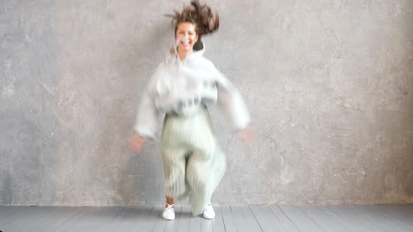 Beautiful cute smiling model jumping. Girl in summer hipster hoodie and skirt