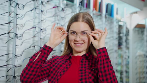 Portrait of a happy woman trying on trendy eyeglasses.