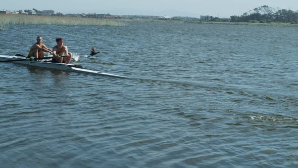 Two male rowers practicing rowing on the lake