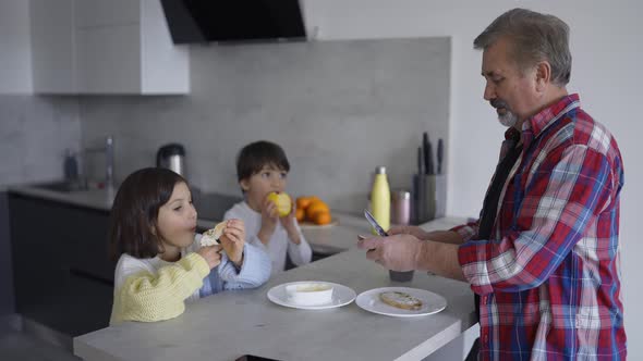 Two Small Children are Eating Sandwiches Made By Grandfather Slow Motion