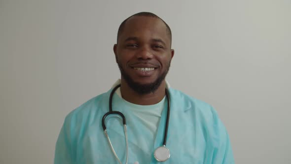 Portrait of Cheerful Positive African American Man Doctor in Lab Coat Smiling at Hospital