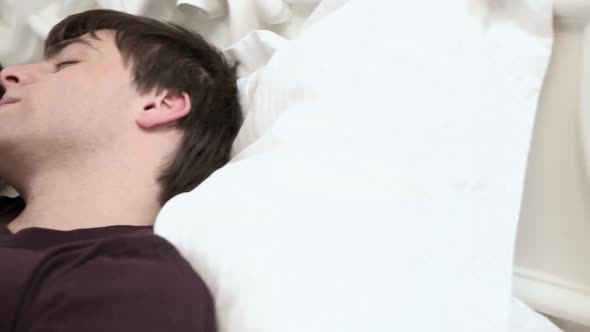 Young couple sleeping in bed, woman opening eyes