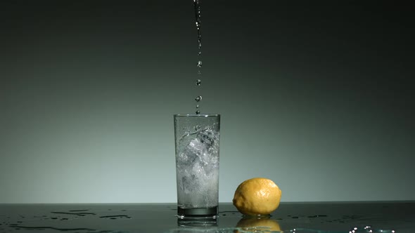 Carbonated liquid pouring into glass filled with ice 