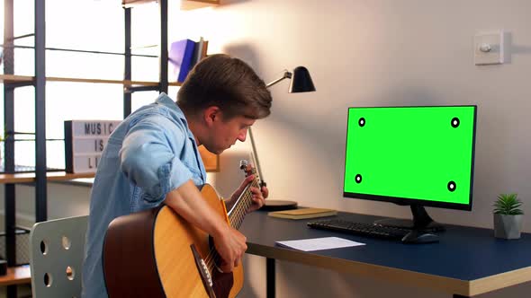 Young Man with Music Book Playing Guitar at Home