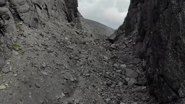 An Aerial View of a Deep Gorge Between Mountains Strewn with Grey Stones