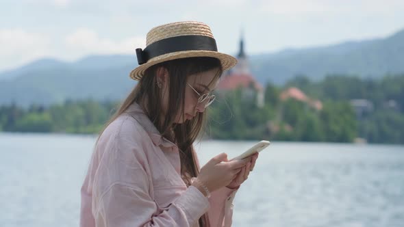 Girl Chatting on Mobile Near Lake Bled Slovenia