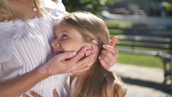 Affectionate Mom's Hands Stroking Daughter's Face