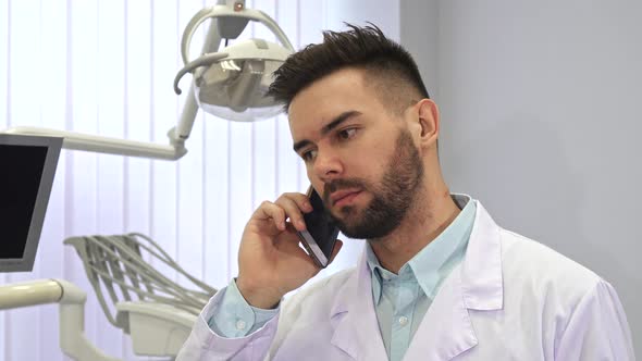 Dentist Talks on the Phone at the Office