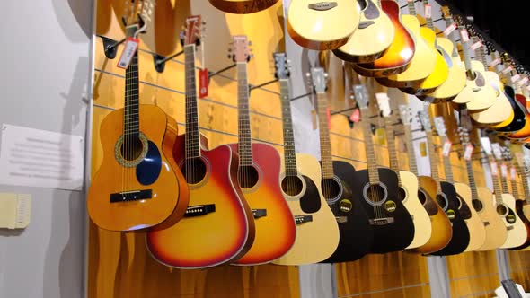 Guitar Shop. Lots of New Multicolored Acoustic Guitars Are Hung in Music Store