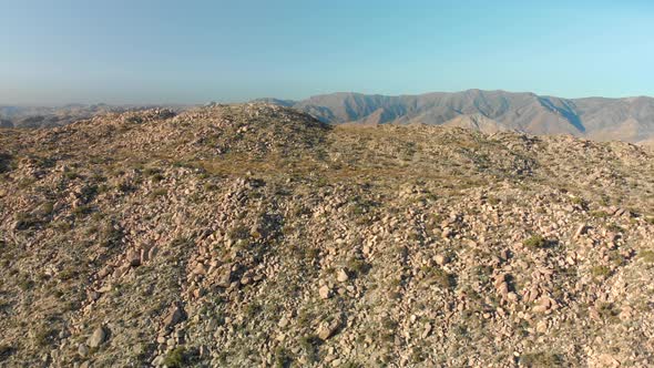 Aerial Dolly Forward over Rocky Hill in Desert