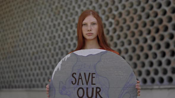 Caucasian Teen Girl Holding Save Our Planet Banner on Street