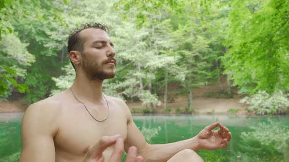 Young man meditating in the forest.