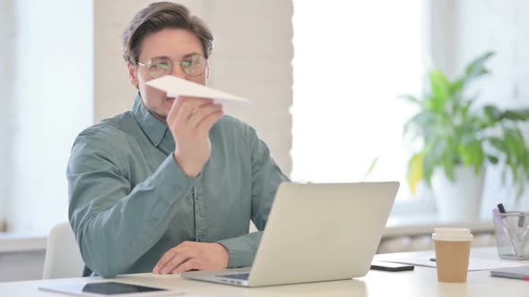 Middle Aged Man with Laptop Flying Paper Plane